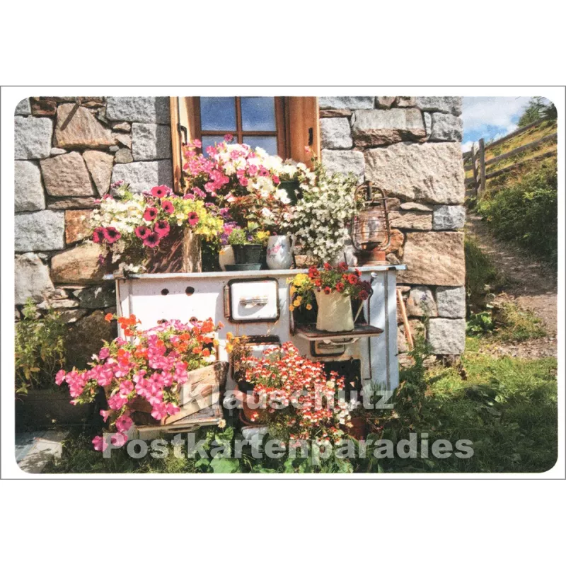 Blühende Küche vor einem Haus in den Bergen - SkoKo Foto Postkarte